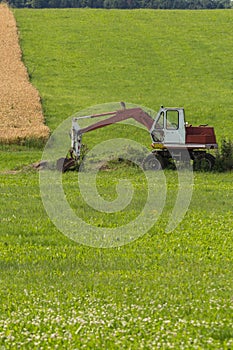 Digger with hut and earth on a corn field rural landscape