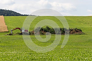 Digger with hut and earth on a corn field rural landscape