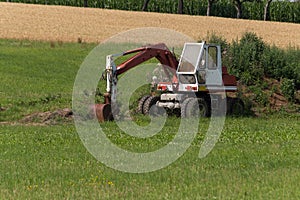 Digger with hut and earth on a corn field rural landscape