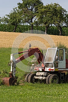 Digger with hut and earth on a corn field rural landscape