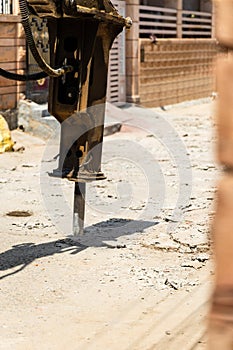 digger machine breaking road for new construction in daylight