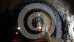 a digger and workers excavating the subway tunnel construction