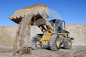 Digging and loading sand with a machine in a quarry