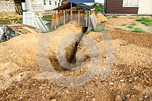 Digging a trench. Earthworks, digging trench. Long earthen trench dug to lay pipe or optical fiber