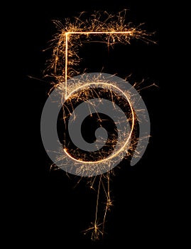 Digit 5 or five made of bengal fire, sparkler fireworks candle isolated on a black background