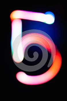 Digit 5. Five. Glowing numbers on dark background. Abstract light painting at night. Creative artistic colorful bokeh. New Year.