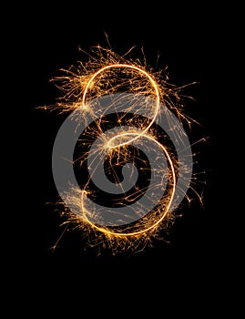 Digit 3 or three made of bengal fire, sparkler fireworks candle isolated on a black background