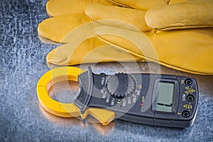 Digital amperemeter protective gloves on metallic background