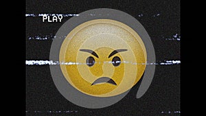 Digital animation of vhs glitch effect over angry face emoji against black background
