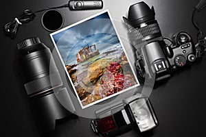 Digital camera equipment around a printed photo of a fisherman house.