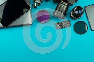 Digital camera with lenses and equipment of the professional photographer on blue background