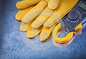 Digital clamp meter protective gloves on metallic background ele