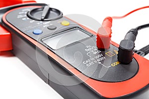 Digital clamp multimeter with probes on a white background