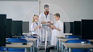 Digital class with two teens and a research worker with a tablet computer