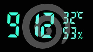 Digital Clock Showing Time on Green Display 9:12 AM, Temperature, Air Humidity