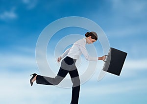 Businesswoman running with briefcase in the sky