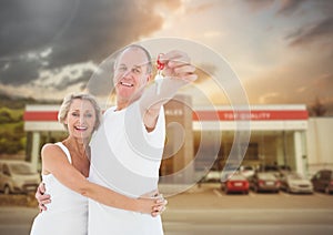 Couple Holding key in front of cars