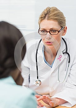 Doctor woman with breast cancer awareness ribbon and patient