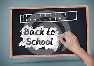 Hand writing Back to school text with ruler on blackboard