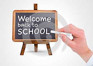 Hand writing Welcome back to school text on blackboard