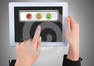Hands holding tablet with feedback smiley satisfaction icons