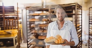 Happy small business owner man holding croissants