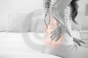 Digital composite of highlighted spine of woman with back pain