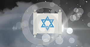 Digital composite image of blue star of david on scroll against cloud in sky at night