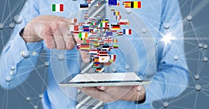 Digital composite image of businessman holding digital tablet with flags and connecting dots