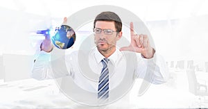 Digital composite image of businessman making hand frame while looking at globe