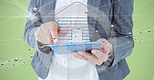 Digital composite image of businesswoman holding tablet computer with home symbol and connecting dot
