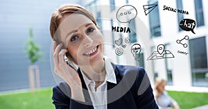 Digital composite image of businesswoman using phone by various icons against building