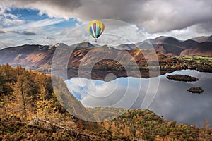 Digital composite image of hot air balloons over Beautiful landscape Autumn image of view from Walla Crag in Lake District, over
