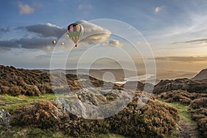 Digital composite image of hot air balloons over Majestic Autumn sunset landscape image from Holme Fell looking towards Coniston