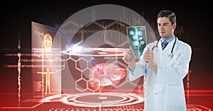 Digital composite image of male doctor looking at x-ray with interface graphics in background