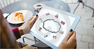 Digital composite image of woman holding tablet PC with cloud icon on screen