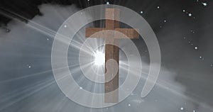 Digital composite image of wooden christian cross against cloud in sky with lens flare at night