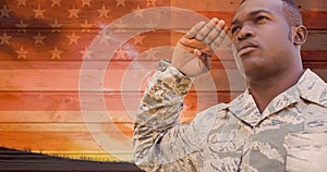 Digital composite image of young african american military man saluting against america flag