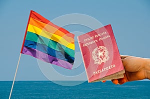 Digital composite of LGBT flag isolated overlooking the ocean with Italian passport in the foreground