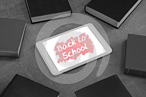 Tablet on a school table with back to school text on screen