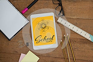 Tablet on a school table with school icons on screen