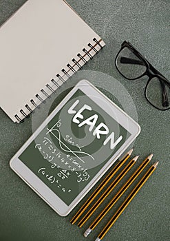 Tablet on a school table with school icons on screen