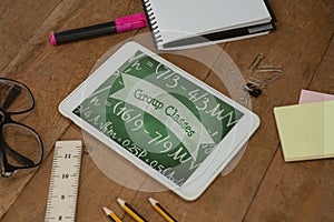 Tablet on a school table with school icons on screen