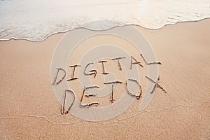 Digital detox concept, words written on the sand outdoor photo
