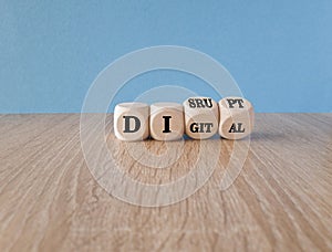 Digital or disrupt symbol. Turned cubes and changed the word digital to disrupt. Beautiful wooden table, blue background. Business