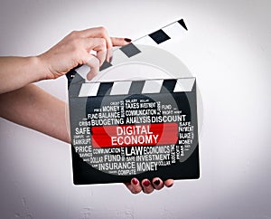 Digital Economy Concept. Female hands holding movie clapper