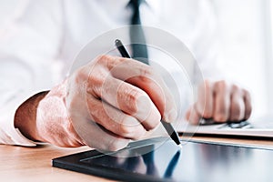 Digital electronic signature or e-signature concept, closeup of signatory hand with stylus and pad