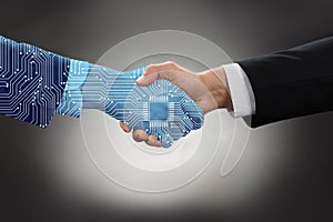 Digital Generated Human Hand And Business Man Shaking Hands photo