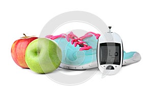 Digital glucometer, apples and sneakers photo