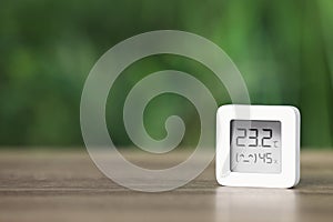 Digital hygrometer with thermometer on table against blurred background. Space for text